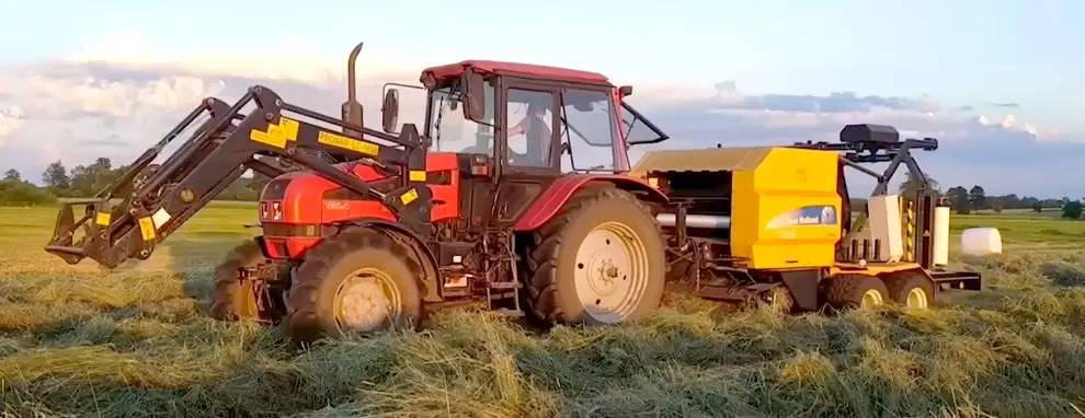 Ciągnik rolniczy z prasoowijarką na polu, zobacz ofertę owijarek Ciągnik rolniczy z prasoowijarką na polu, zobacz ofertę owijarek